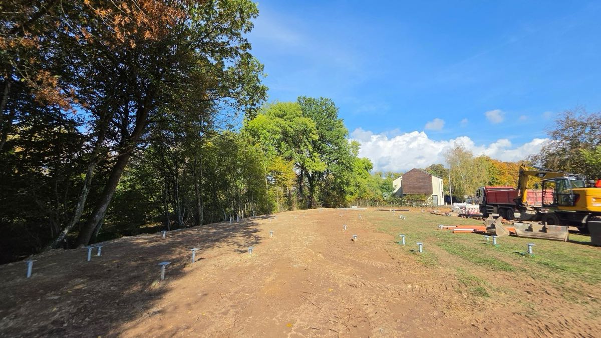 Rijen geplaatste schroefpalen op een werf aan een bosrand
