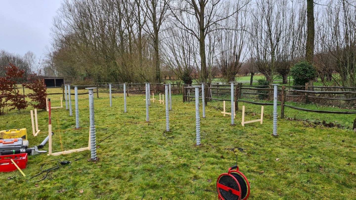 Raster van geplaatste schroefpalen in een grasveld